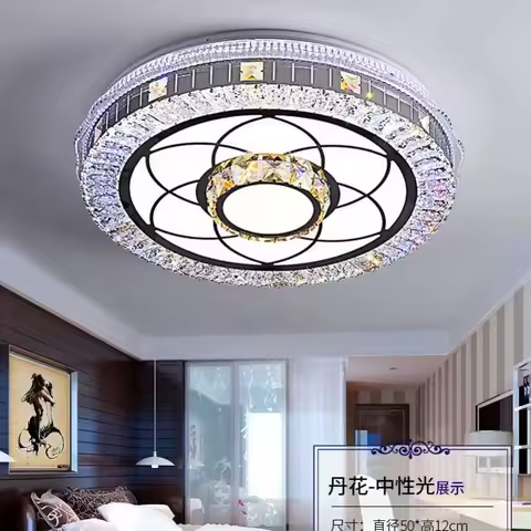 Silver crystal LED circle pendant light hanging above a modern dining table